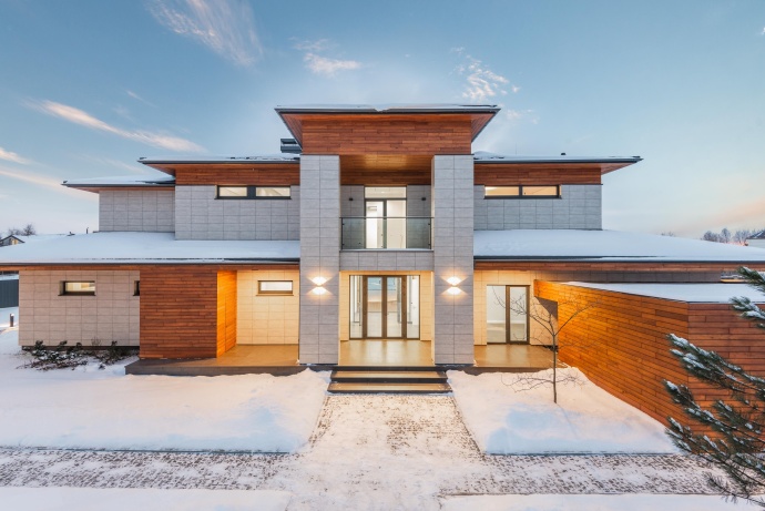Big house with snow on the ground and roof