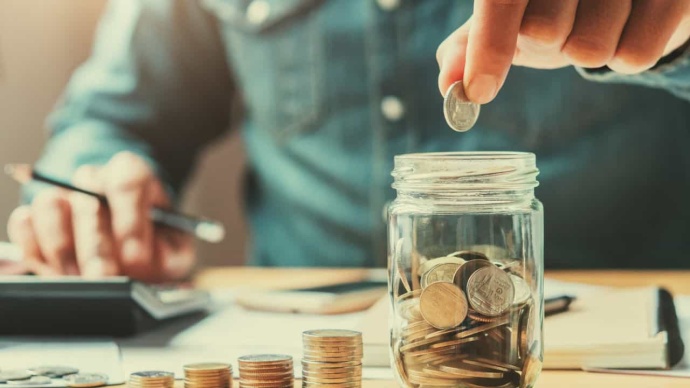 Man putting coin into piggy bank