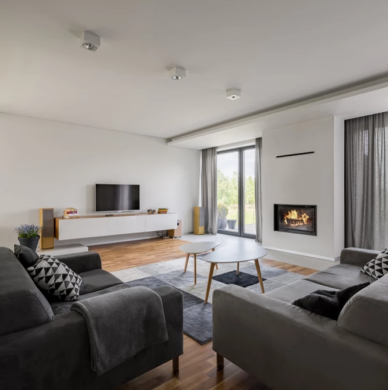 Living room with sofas, tv, fireplace and ceiling-mounted lighting Living room with TV and fireplace