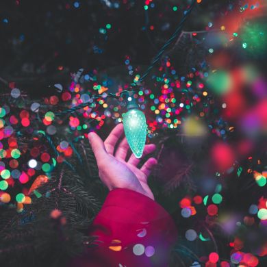 Colorful Christmas lighting in hand Colorful Christmas lighting in hand
