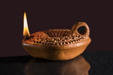 Old clay candle with flame Old clay candle with flame
